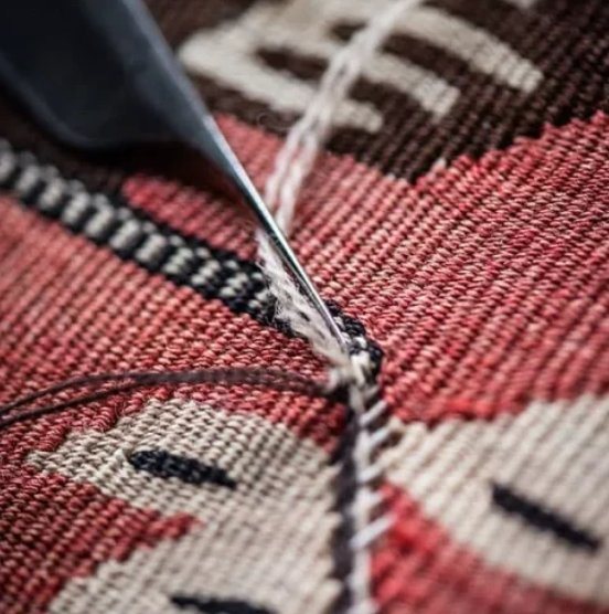Réparation artisanale d'un kilim au crochet